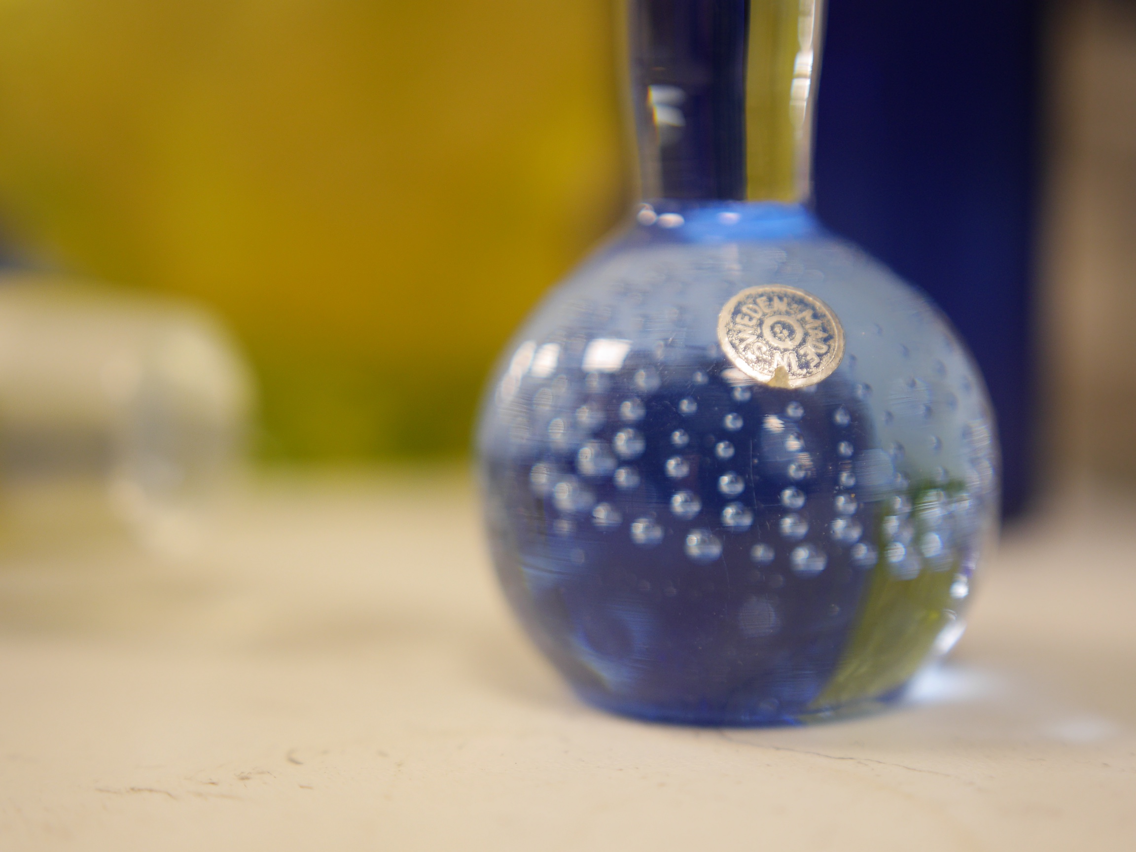 A yellow glass putti decorated vase, a blue glass decanter and other blue glassware, vase 18cm high. Condition. - one glass broken